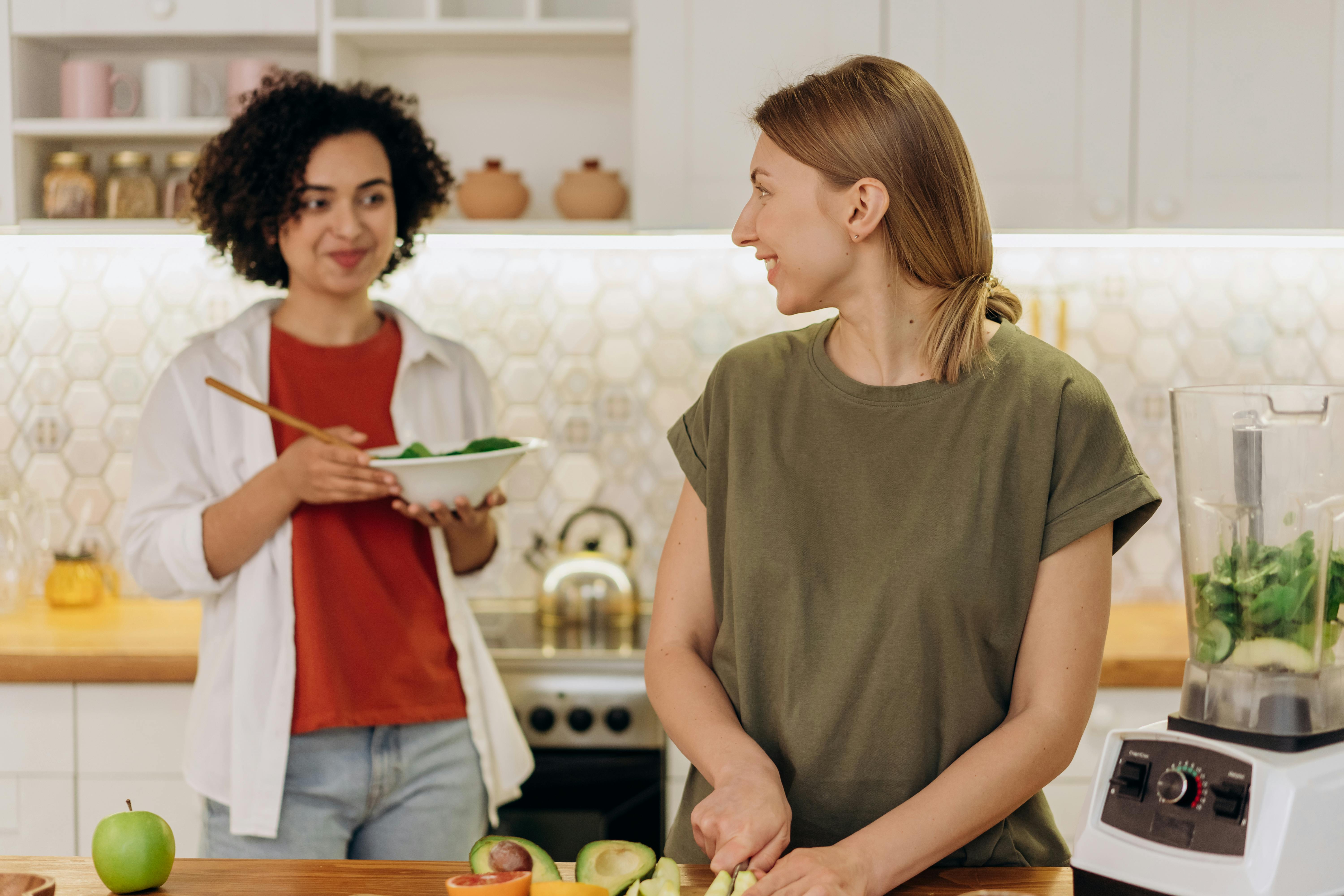 Women preparing healthy meals together in kitchen