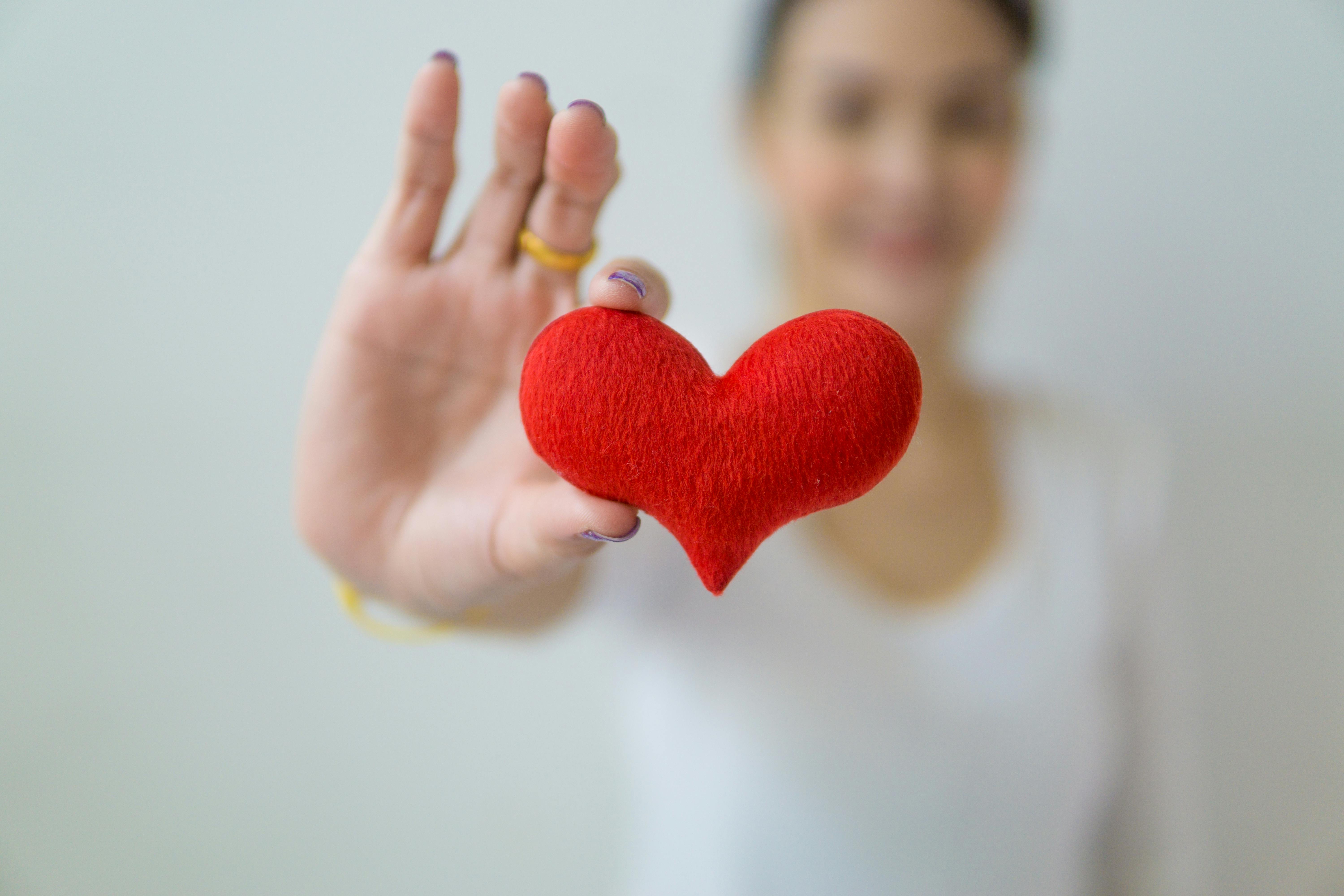 Hands holding red heart symbolizing healthcare and wellness